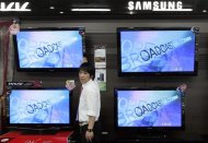 An electronics shop salesperson sells flat screen TVs of Samsung Electronics displayed at a shop in Seoul October 6, 2009. REUTERS/Choi Bu-Seok