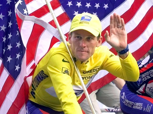 FILE - This July 23, 2000 file photo shows Tour de France winner Lance Armstrong riding down the Champs Elysees with an American flag after the 21st and final stage of the cycling race in Paris. The superstar cyclist, whose stirring victories after his comeback from cancer helped him transcend sports, chose not to pursue arbitration in the drug case brought against him by the U.S. Anti-Doping Agency. That was his last option in his bitter fight with USADA and his decision set the stage for the titles to be stripped and his name to be all but wiped from the record books of the sport he once ruled. (AP Photo/Laurent Rebours, File)