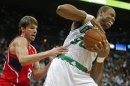 Celtics center Collins grabs a rebound away from Hawks guard Korver in the first half of their NBA basketball game in Atlanta