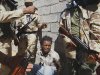 Libya fighters arrest a man from Nigeria, who they allege is a Gadhafi loyalist, as they take control of Moammar Gadhafi loyalists villages in the desert some 730 km south of Tripoli, at Mahruga, 50 km north of the southern city of Sebbah, Libya, Saturday, Sept. 17, 2011. Revolutionary fighters struggled to expand the offensive into Moammar Gadhafi's hometown Saturday with street-by-street battles and commanders seeking to break open a new front against loyalist forces fiercely defending the most symbolic stronghold remaining from the shattered regime. (AP Photo/Francois Mori)