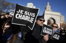 Attendees hold "Je Suis Charlie" (I am Charlie) signs as several hundred people gather in solidarity with victims of two terrorist attacks in Paris, one at the office of weekly newspaper Charlie Hebdo and another at a kosher market, in New York's Washington Square Park, Saturday, Jan. 10, 2015. (AP Photo/Jason DeCrow)