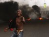 A angry youth protest in front of a burning barrier following the removal of a fuel subsidy by the government in Lagos, Nigeria, Tuesday, Jan. 10, 201. Angry youths erected a burning roadblock outside luxury enclaves in Nigeria's commercial capital Tuesday as a paralyzing national strike over fuel prices and government corruption entered its second day.(AP Photo/Sunday Alamba)