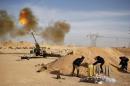 Libya Dawn fighters fire an artillery cannon at IS militants near Sirte