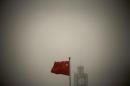 A Chinese national flag flies in front of Beijing Telegraph Building on a hazy morning in central Beijing