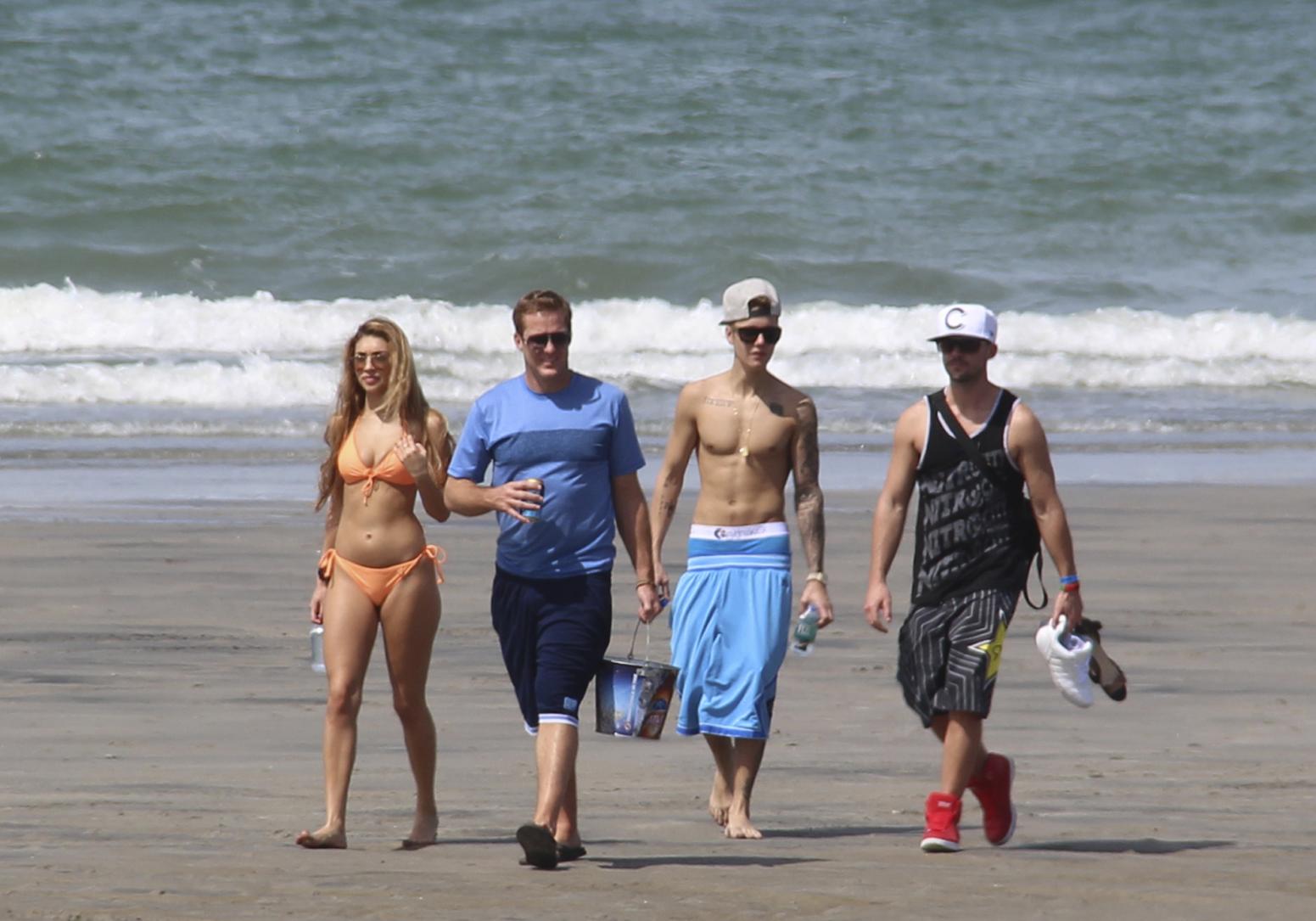 Justin Bieber, second right, and Chantel Jeffries, far left, walk with unidentified people on a beach in Punta Chame, Panama, Saturday, Jan. 25, 2014. A Panamanian radio and television host says trouble-plagued pop star Justin Bieber has been relaxing on a beach in Panama on a vacation from the United States. Eddy Vasquez was filming a show at the Pacific Coast resort in Punta Chame, about 90 miles west of Panama City, when he spotted Bieber and members of his entourage walking along the beach. (AP Photo/Eddy Vasquez)