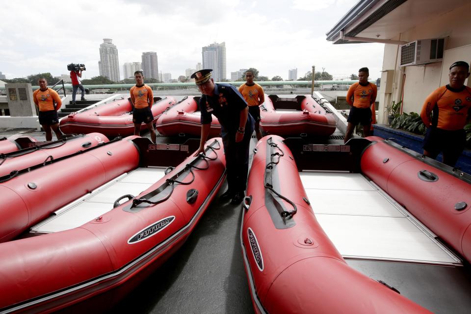 Philippine Coast Guard Chief Rear Adm. Rodolfo Isorena checks newly-acquired rubber boats following blessing ceremony Wednesday, Nov. 6, 2013 in Manila, Philippines. Isorena said the new single-hull aluminum boats and rubber boats will be deployed to central Philippines in preparation for the onslaught of super typhoon "Haiyan" which is expected to make a landfall in central Philippines this weekend. (AP Photo/Bullit Marquez)