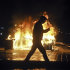 A man walks by a fire burning in University Square, the scene of the first anti-communist protests in 1989, in Bucharest, Romania, early Monday, Jan. 16, 2012. Romania's government called an emergency meeting late Sunday to discuss violent protests that show no sign of abating after demonstrators angry about austerity measures hurled stones and firebombs at police. At least six people were injured. (AP Photo/Octav Ganea)