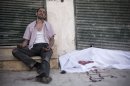 A man cries near the body of his brother, killed by a Syrian Army sniper, near Dar El Shifa Hospital in Aleppo, Syria, Thursday, Sept. 27, 2012. (AP Photo/Manu Brabo)
