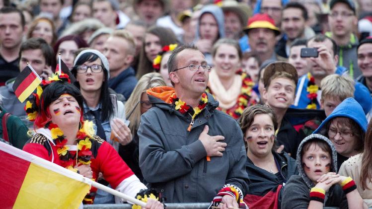 German soccer fans sing the German national anthem during the soccer World Cup 2014 match Germany vs Ghana at a public viewing zone in Chemnitz, central Germany, Saturday, June 21, 2014