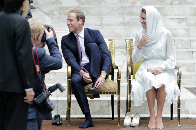 Britain's Prince William and Catherine, Duchess of Cambridge, take off their shoes before visiting the As-Syakirin Mosque at KLCC in Kuala Lumpur