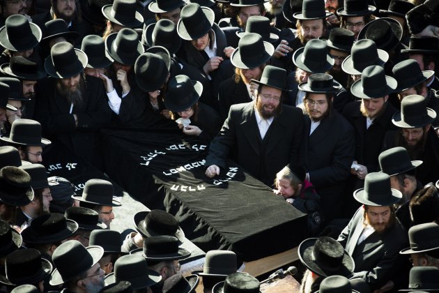 Members of the Satmar Orthodox Jewish community congregate for the funeral of two expectant parents who were killed in a car accident, Sunday, March 3, 2013, in the Brooklyn borough of New York. A driver struck the car the couple were riding in early Sunday morning, killing both parents while their baby, who was born prematurely, survived and is in critical condition. (AP Photo/John Minchillo)