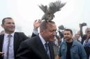 A grouse sits Turkish President Tayyip Erdogan's head as he visits a facility of the Forest and Water Management Ministry in Rize, Turkey