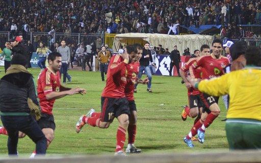 Al Ahli Soccer players try to leave the stadium as chaos erupts at a soccer stadium in Port Said city