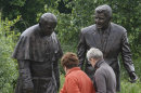 People look at a new statue of former President Ronald Reagan and Pope John Paul II that was unveiled in Gdansk, Poland, on Saturday, July 14, 2012. The statue honors the two men whom many Poles credit with helping to topple communism. (AP Photo/Czarek Sokolowski)