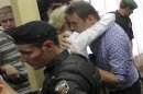 Russian opposition leader Alexei Navalny, embraces his wife Yulia at a court in Kirov, Russia Thursday, July 18, 2013. Alexei Navalny, one of the Russian opposition's leading figures, was convicted of embezzlement Thursday and sentenced to five years in prison. (AP Photo/Dmitry Lovetsky)