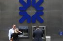 A man uses a cashpoint machine outside a branch of the Royal Bank of Scotland in the City of London