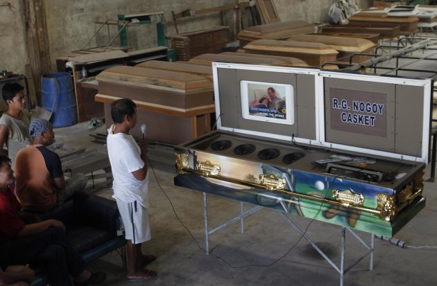 Workers try out a coffin equipped …