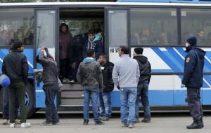 Migrants enter a bus at a Croatia-Slovenia border crossing in Lendava, Slovenia