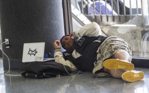 Passenger Tasi Lua, 25, of Hawaii, rests in Terminal …