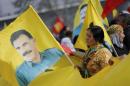 People hold flags with the image of Ocalan during a demonstration in Duesseldorf