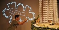 A man takes a photo of a model of Opus Hong Kong at a Frank Gehry exhibition in Hong Kong in 2011. The price for the unit, which takes up the entire 8th floor of the 12-storey building, is believed to be Asia's most expensive apartment, reports say