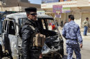 Security forces inspect the scene of a car bomb attack in Ramadi, 70 miles (115 kilometers) west of Baghdad, Iraq, Tuesday, March 20, 2012. Officials say attacks across Iraq have killed and wounded scores of people in a spate of violence that was dreaded in the days before Baghdad hosts the Arab world's top leaders. (AP Photo)