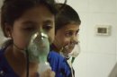 Children, affected by what activists say was a gas attack, breathe through oxygen masks in the Damascus suburb of Saqba