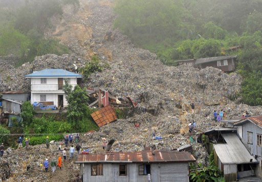 Rubbish swamps houses after heavy rains from Typhoon Nanmadol caused a  retaining wall at a landfill to collapse