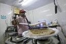 An inmate prepares food inside the kitchen of a restaurant run by Tihar Jail authorities in Delhi