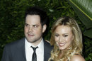FILE - In this May 11, 2011 file photo, actress Hilary Duff, right, and her husband Mike Comrie arrive at an Evening of 