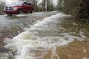 A vehicle drives along a flooded section of Hayneville Road in west Montgomery, Ala., on Christmas morning Friday, Dec. 25, 2015. The line of springlike storms continued marching east Thursday, dumping torrential rain that flooded roads in Alabama and caused a mudslide in the mountains of Georgia. (Mickey Welsh/The Montgomery Advertiser via AP) MANDATORY CREDIT