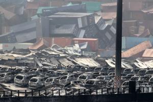 Damaged cars and containers are seen at the site of …