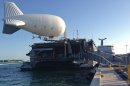 A balloon-like craft known as an aerostat is shown attached to the back of the U.S. Navy high speed vessel Swift docked in Key West, Florida, Friday, April 26, 2013. The U.S. Navy on Friday began testing two new aerial tools, borrowed from the battlefields of Afghanistan and Iraq, that officials say will make it easier to detect, track and videotape drug smugglers in action. (AP Photo/Ben Fox)