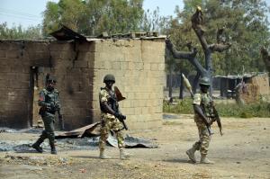 Soldiers and policemen walk past burnt houses on February&nbsp;&hellip;
