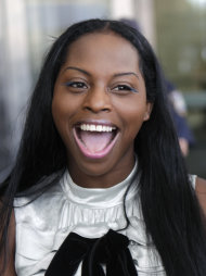 Inga Marchand, also known as Foxy Brown, laughs while talking to reporters after leaving court in New York, Tuesday, July 12, 2011. Charges that rapper Foxy Brown violated a court order by mooning her neighbor have been dropped. (AP Photo/Seth Wenig)