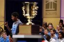 Ansun Sujoe spells a word correctly behind the winner's trophy during the 2013 Scripps National Spelling Bee at the Gaylord National Resort and Convention Center at National Harbor in Maryland