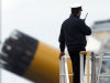 An Italian Navy officer talks on a walkie-talkie in the harbor of the Tuscan island of Giglio, Italy, where the cruise ship Costa Concordia run aground, Monday, Jan. 23, 2012. Salvage experts can begin pumping fuel from a capsized cruise ship as early as Tuesday to avert a possible environmental catastrophe and the ship is stable enough that search efforts for the missing can continue, Italian officials said. (AP Photo/Pier Paolo Cito)
