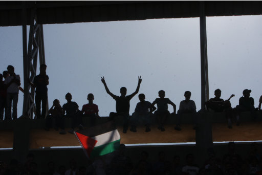 Palestinians watch their national soccer team play against Afghanistan national team in the West bank city of Ramallah, Sunday July 3, 2011. The Palestinian national soccer team drew 1-1 against Afghanistan on Sunday, a score that advances the Palestinians to the next qualifying round for the World Cup set for 2014 in Brazil. (AP Photo/Nasser Shiyoukhi)