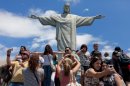 Tourists have their pictures taken in front of the statue of Christ the Redeemer in Brazil