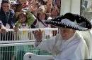 Pope Benedict XVI waves from the popemobile wearing a Mexican sombrero as he arrives to give a Mass in Bicentennial Park near Silao, Mexico, Sunday March 25, 2012. (AP Photo/Eduardo Verdugo)
