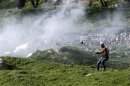 A Palestinian protester uses a sling shot to throw a stone at Israeli soldiers and border policemen during clashes near Nablus