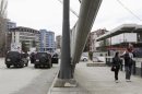 Pedestrians pass by an Italian Carabinieri on the main bridge in the ethnically divided town of Mitrovica