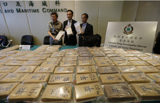 Funcionarios aduaneros  presentan los paquetes de cocaína en las instalaciones del Departamento de Aduanas de Hong Kong el viernes 6 de julio del 2012. Las autoridades realizaron la mayor redada antidrogas que se haya registrado en la ciudad, con la incautación de 649 kilogramos (1.430 libras) de cocaína en un contenedor procedente de Ecuador,  por un valor de 98 millones de dólares en su venta callejera. (Foto AP/Kin Cheung)