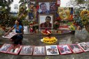 A woman wipes photos of late President Hugo Chavez at a makeshift altar set in his honor at the main square of Sabaneta, western Venezuela on Saturday, March 9, 2013. Chavez, who died of cancer on March 5, 2013 was born in Sabaneta. His former home has been turned into the local headquarters of the United Socialist Party of Venezuela, PSUV. (AP Photo/Esteban Felix)