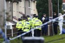 Police and forensic officers gather at the scene where two female police officers were killed in Hattersley near Manchester