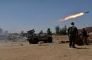 Shiite fighters launch a rocket towards Islamic State militants on the outskirt of Bayji