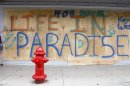 Shira Edllan Gervasi, of Israel, puts her name on plywood protecting a storefront in Key West, Fla., in anticipation of Tropical Storm Isaac on Saturday, Aug. 25, 2012. Isaac's winds are expected to be felt in the Florida Keys by sunrise Sunday morning. (AP Photo/Alan Diaz)