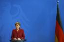 German Chancellor Merkel listens to Canadian Prime Minister Harperduring joint news conference at Chancellery in Berlin