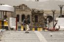 Houthi militant walks past a building of the Defence Ministry compound damaged by a Saudi-led air strike in Yemen's capital Sanaa