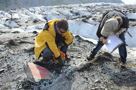 Dr. Greg Berg (L) and Ms. Kelley Esh, anthropologists leading a specialized recovery team with the Joint POW/MIA Accounting Command, verify a location point as they assess a historic aircraft wreckage site at Colony Glacier, Alaska, in this June 26, 2013 handout photo released to Reuters July 8, 2013. REUTERS/U.S. Navy Mass Communications Specialist 3rd Class Clifford Bailey/Department of Defense/Handout via Reuters